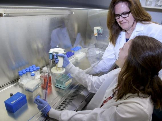 Graduate Students holding pipette in lab