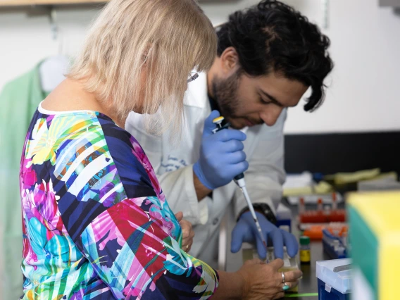 Dr. Cindy Miranti works with a member of her team on a cell culture for one of their projects