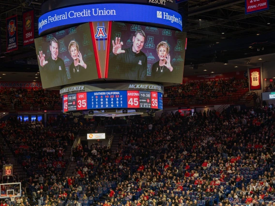 Ginny L Clements and UArizona Mens BB coach on jumbotron