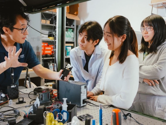 Engineering students working with their professor