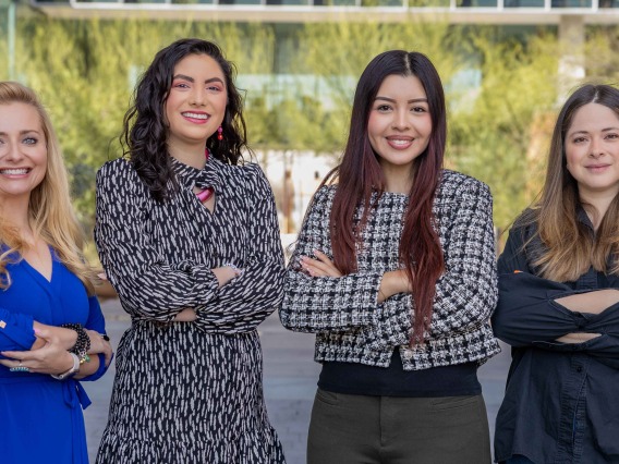 Four University of Arizona researchers from the HPV, dysplasia and cervical cancer study stop for a photo outside a building on campus.