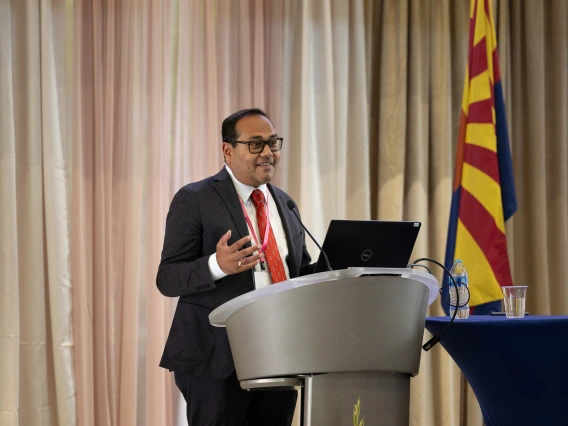 A doctor speaks at the podium during the symposium.