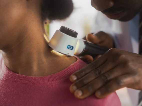 A doctor examining patient skin for sun damage