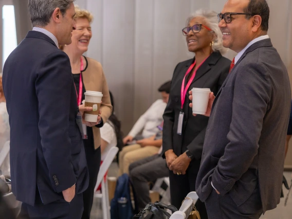 Four people talk at the symposium.