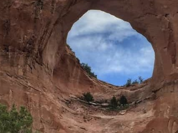The sky shows through a hole in a rock formation in Windowrock, Arizona.