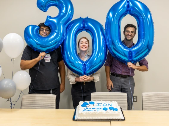 Three pulmonologists hold balloons celebrating 300 biopsies