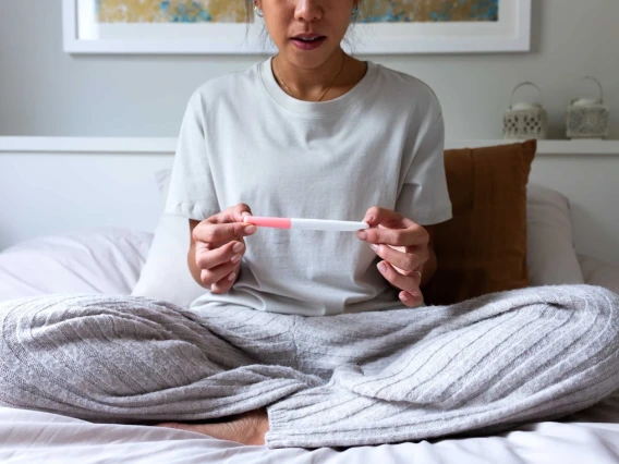 Woman examining home pregnancy test.