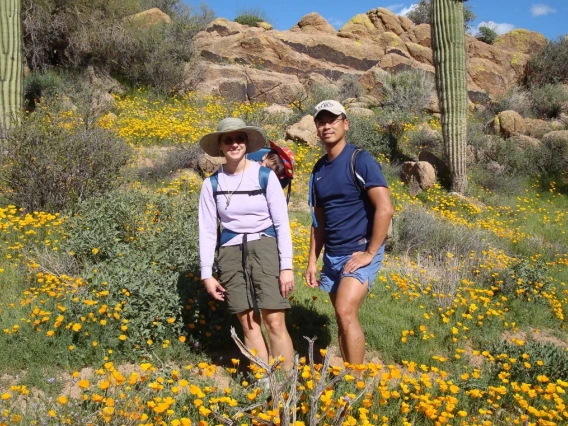 Karen Hastings and her husband walk along a mountain trail on a sunny day in Tucson.