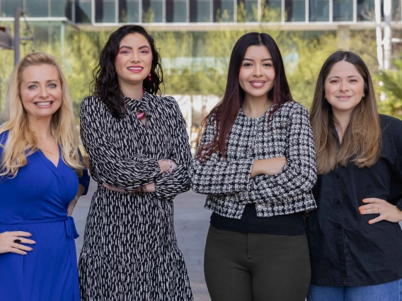 Melissa Herbst-Kralovetz and three students smile for a photo outside of the BIO5 building at the University of Arizona. 