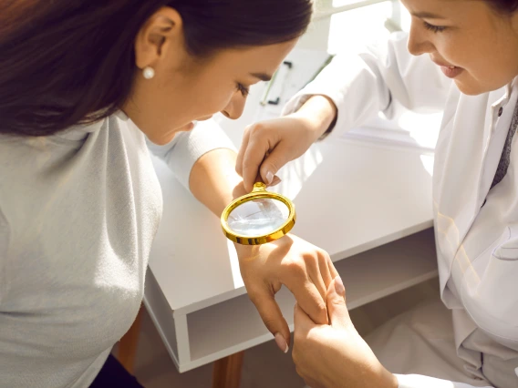Dermatologist examining a patient's hand.