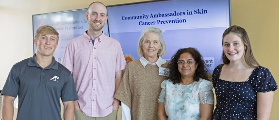 Group of five Skin Cancer Institute ambassadors pose for a photo indoors.