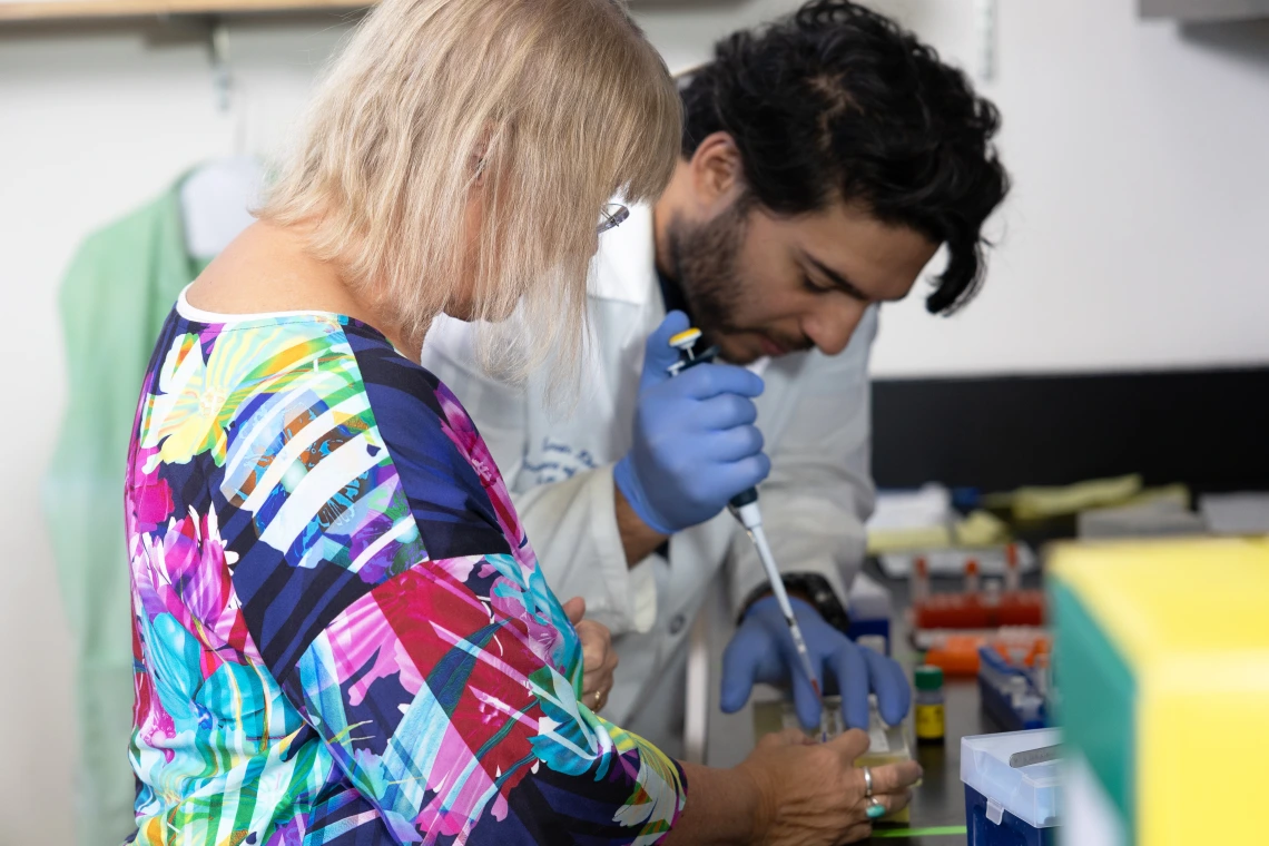 Dr. Cindy Miranti works with a member of her team on a cell culture for one of their projects