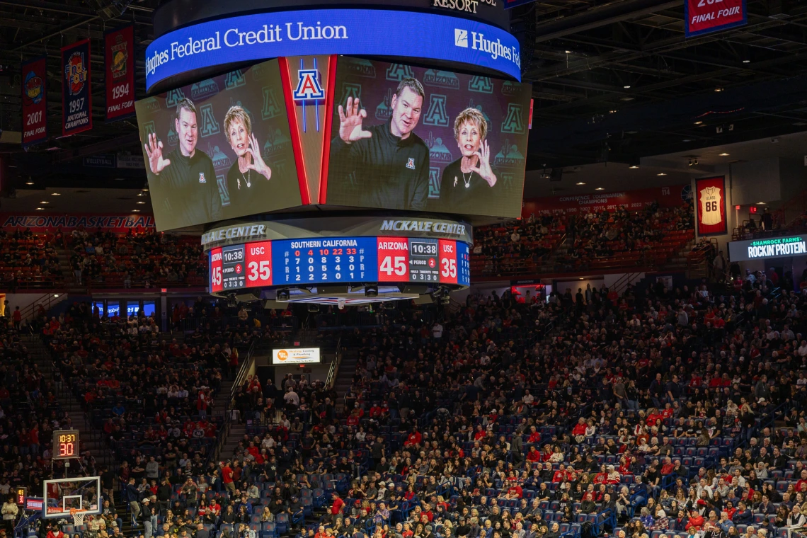 Ginny L Clements and UArizona Mens BB coach on jumbotron