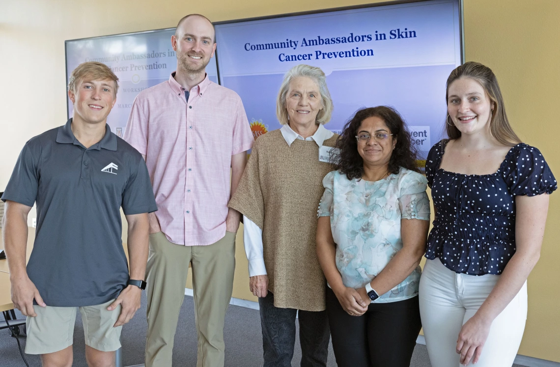 Four people pose for a photo at the sun safety community ambassador training.