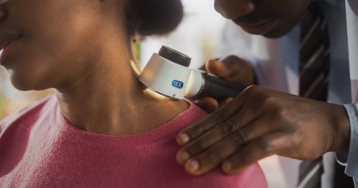 A doctor examining patient skin for sun damage