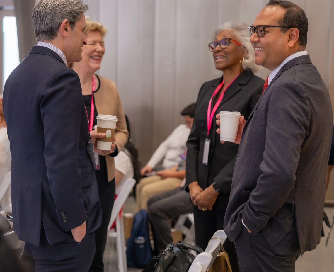 Four people talk at the symposium.