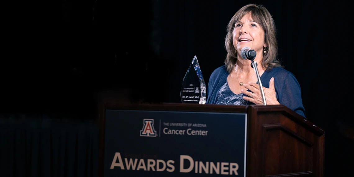 Cynthia Thomson holds her glass Lifetime Achievement Award at this year's UACC Awards Dinner.