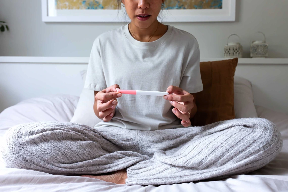 Woman examining home pregnancy test.