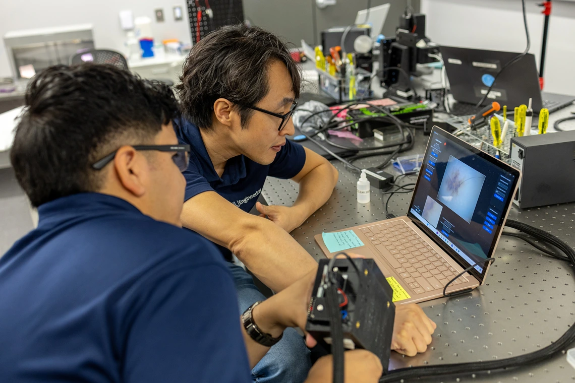 DK Kang in his laboratory working with a graduate student
