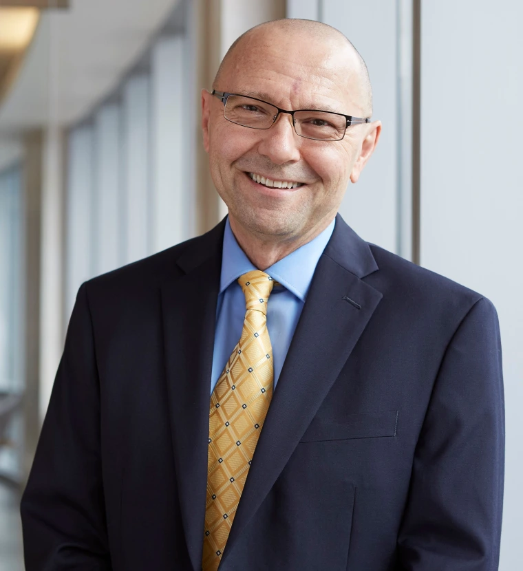 Portrait of Dan Theodorescu wearing a suit and glasses