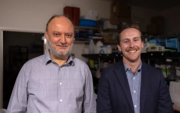 Dr. Carlos Caulin and his T32 student, Dr. Zachary Compton, smile for a photo in Dr. Caulin's lab.