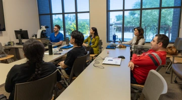 Students sit at tables in a classroom n the Banner – University Medicine Multispecialty Services Clinic..