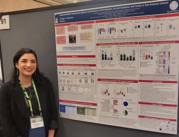 GUIDeS student poses in front of her poster.