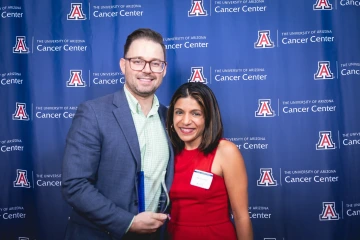 Aaron Scott, MD, holds his Award for Teaching and Mentoring Excellence with Rachna Shroff, MD.