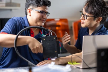 student Rafael Romero practices using his latest skin cancer detection prototype on Professor D.K. Kang in the Kang Lab at the University of Arizona.