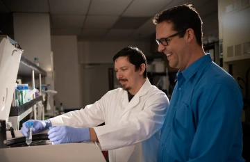 T32 scholar Jesse Altemus works in a lab under the guidance of Jacob Schwartz, associate director of the cancer center Cancer Research and Training Coordination Program.