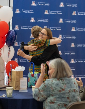 Roe hugs a coworker at her retirement party.