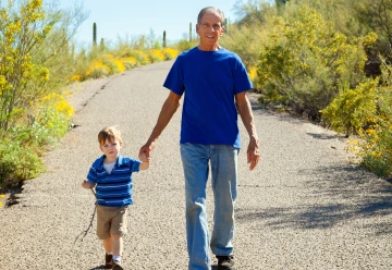 A grandfather and grandson hold hands and go for a walk in Tucson.