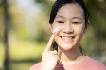 Student applies sunscreen.