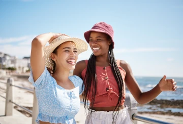 Two people smiling and wearing hats.