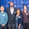 Eight Cancer Center award winners take a photo in front of a backdrop at an awards dinner.