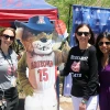 Three people pose with a cutout of the U of A mascot, Wilbur Wildcat outdoors in front of the North Cancer Center