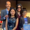 Dr. Rachna Shroff with husband and two children smiling for an outdoor photo..