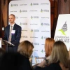 Person speaks at podium indoors in front of an audience. 