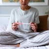 Woman examining home pregnancy test.