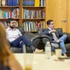 two people sit in chairs at a meeting.