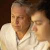 Gregory Rogers examines a lab sample with his student in the lab.