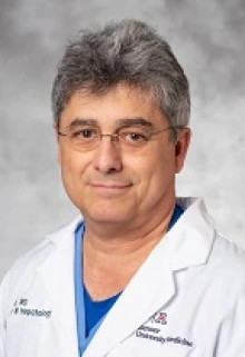 Rolando Leal, MD, smiles in a portrait waring a white lab coat.
