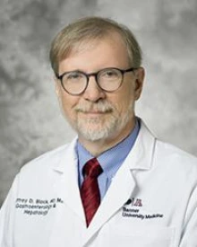Geoffrey Block, MD, smiles for a portrait in his white lab coat