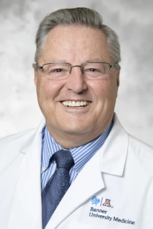 Oleh Haluszka, MD, smiles in a photo wearing his lab coat.