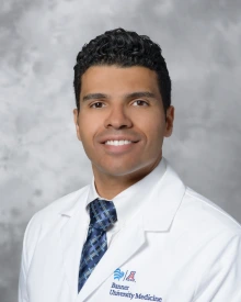 Portrait of Rami Sulaiman wearing a lab coat and tie.