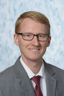 Portrait of David Nolte wearing a suit, tie and glasses.