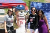 Three people pose with a cutout of the U of A mascot, Wilbur Wildcat outdoors in front of the North Cancer Center