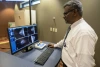 Dr. Vedantham in front of breast cancer screening display monitor.